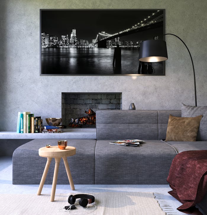 Services Modern gray living room featuring a fireplace and cityscape artwork, creating a cozy ambiance.